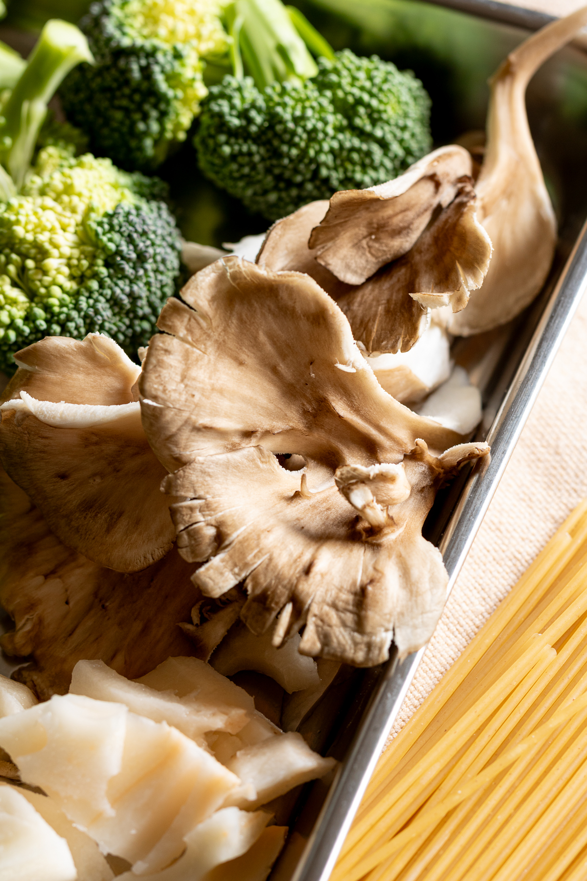 Vegan creamy pasta ingredients maitake mushrooms, broccoli, lotus root