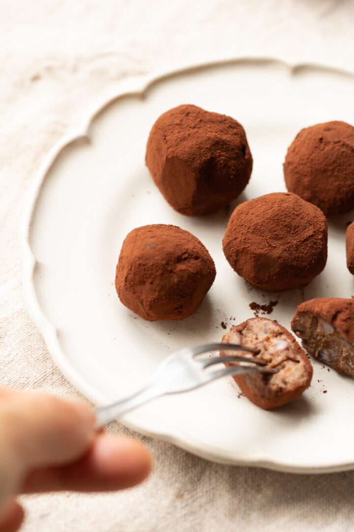Vegan nama chocolate truffles dusted with cocoa powder on a plate