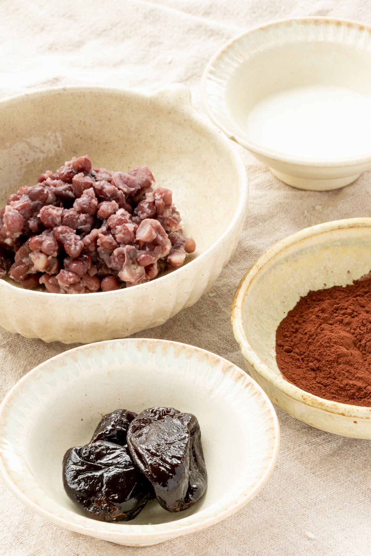 Ingredients for vegan adzuki bean truffles: cooked adzuki beans, prunes, cocoa powder, and coconut oil