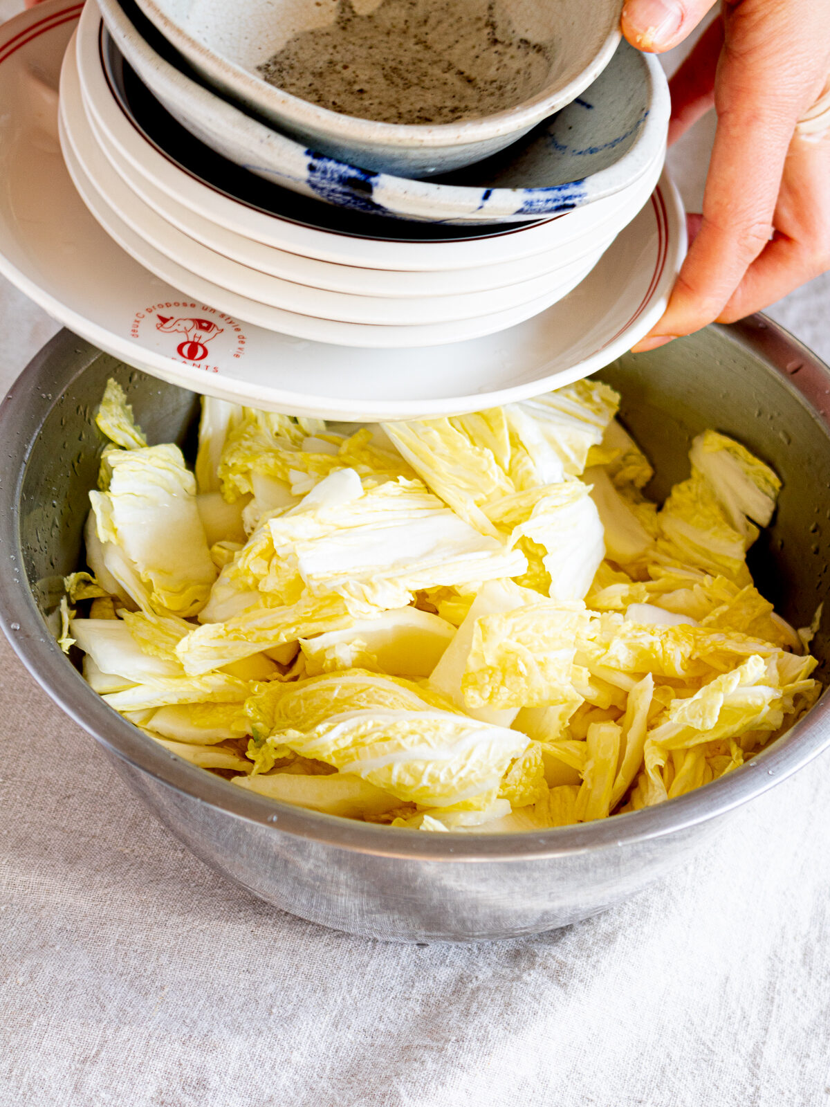 Salted napa cabbage weighted down for vegan kimchi