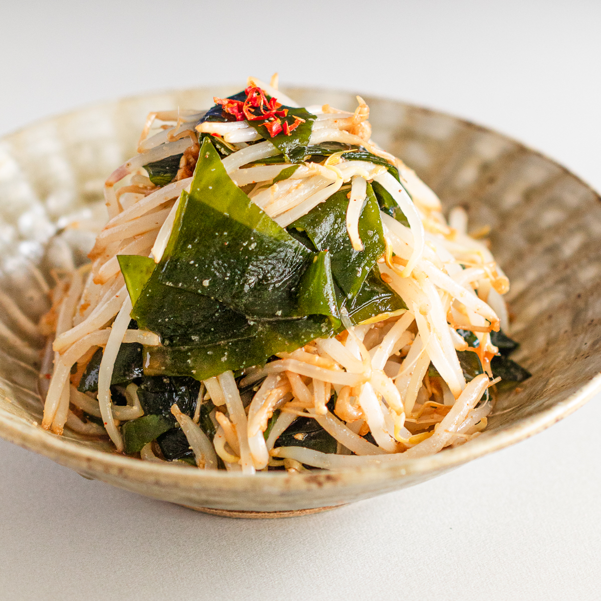 Korean-style salad with crisp bean sprouts and wakame, tossed in mild vegan bibimbap sauce for extra umami