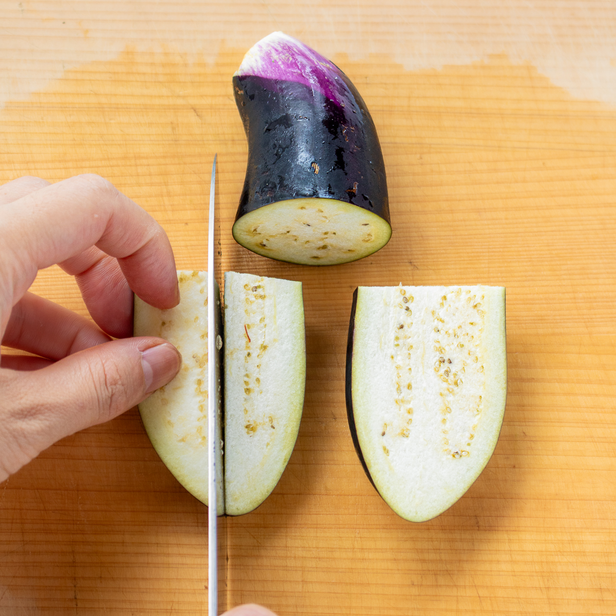 How to cut eggplant into wedges: first cut crosswise, then lengthwise