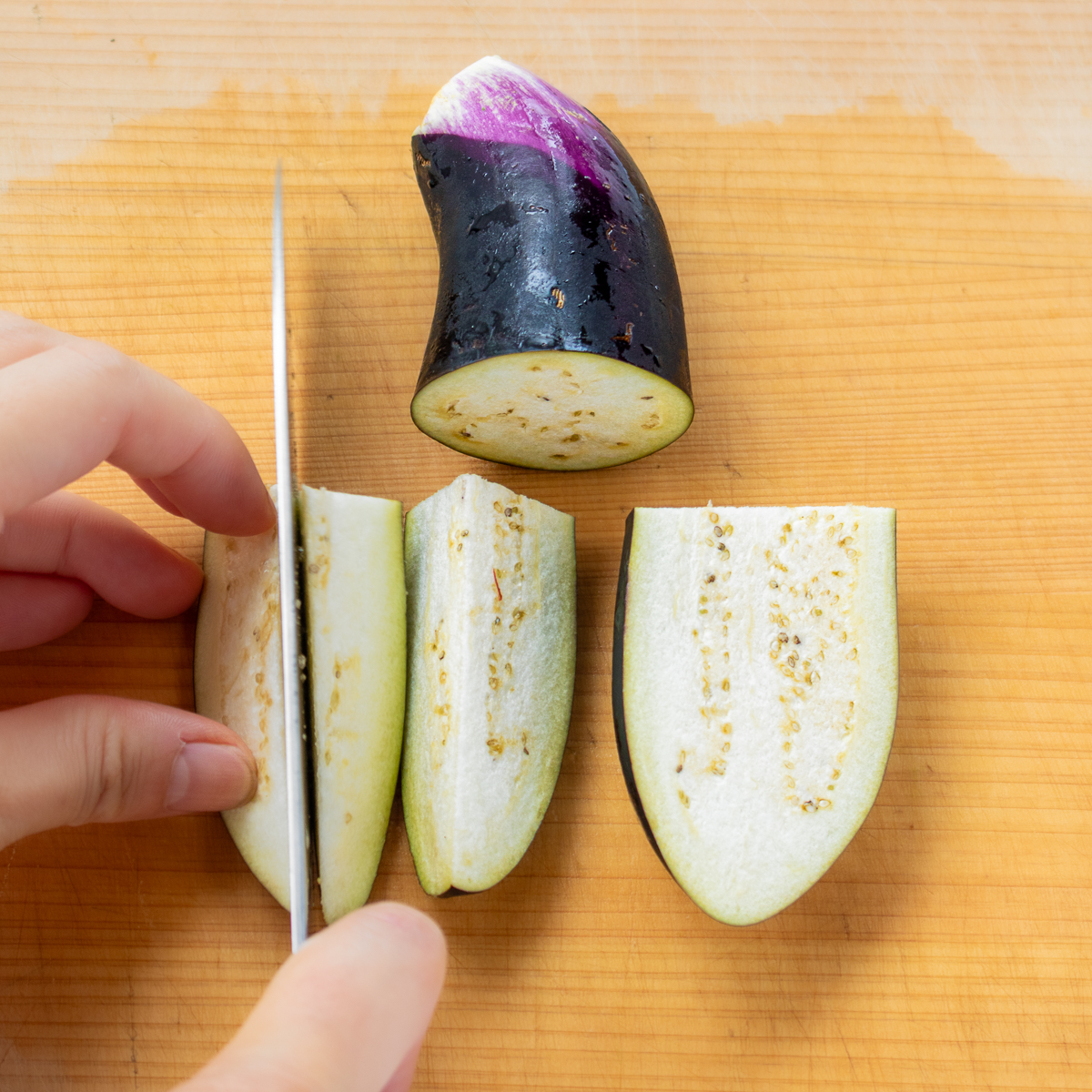  Slicing eggplant into thick wedges for even cooking