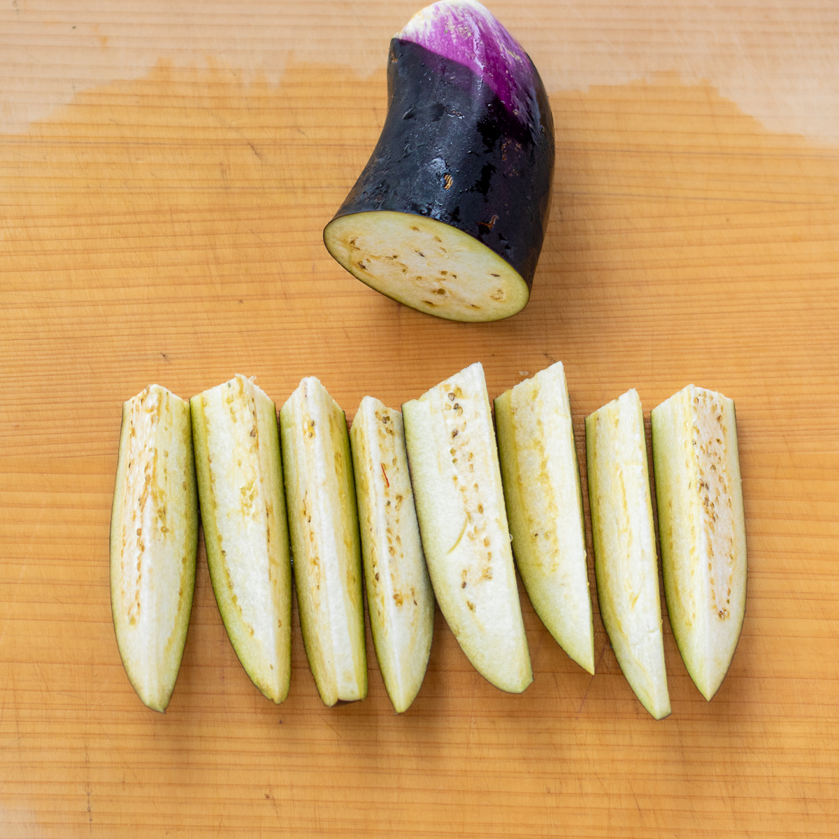 Eggplant wedges lined up after cutting