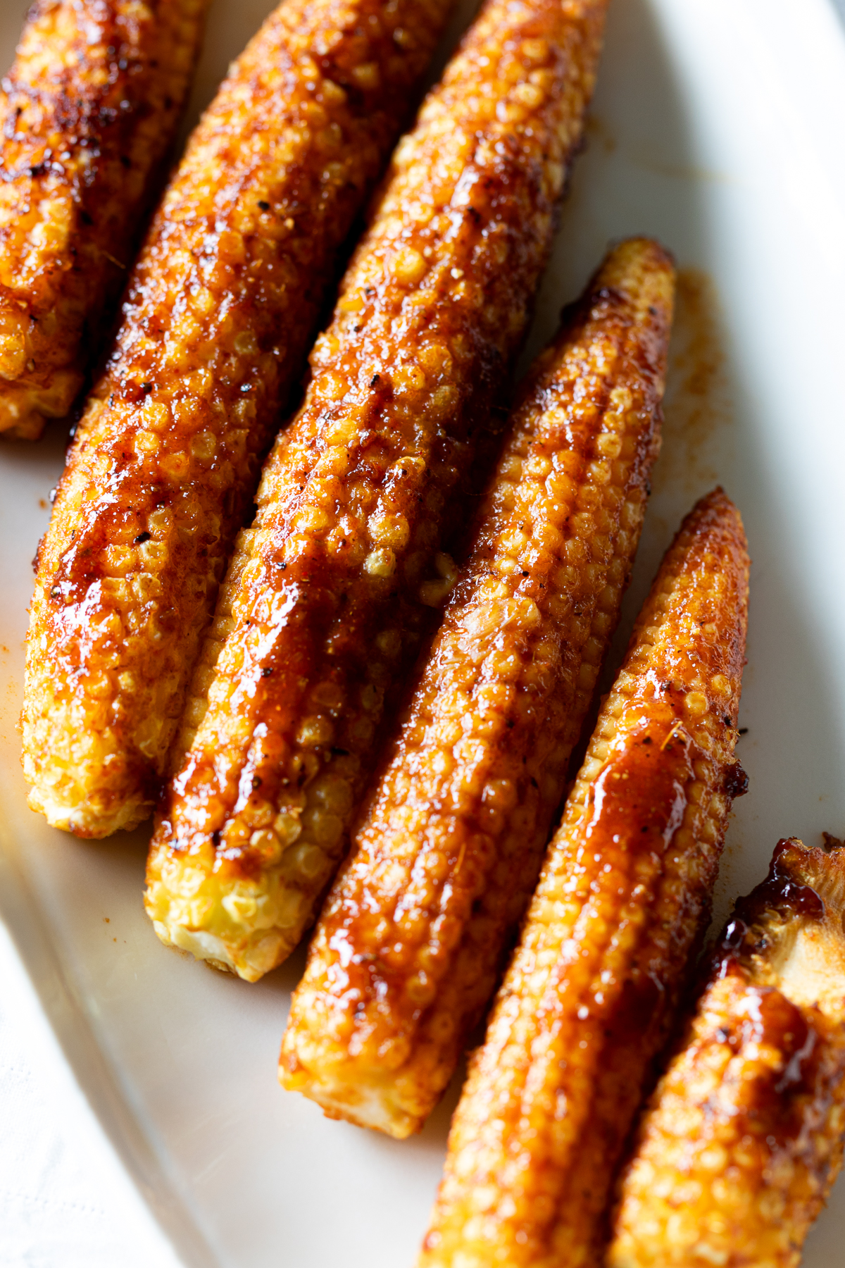 Close-up of crispy roasted baby corn with golden brown edges.