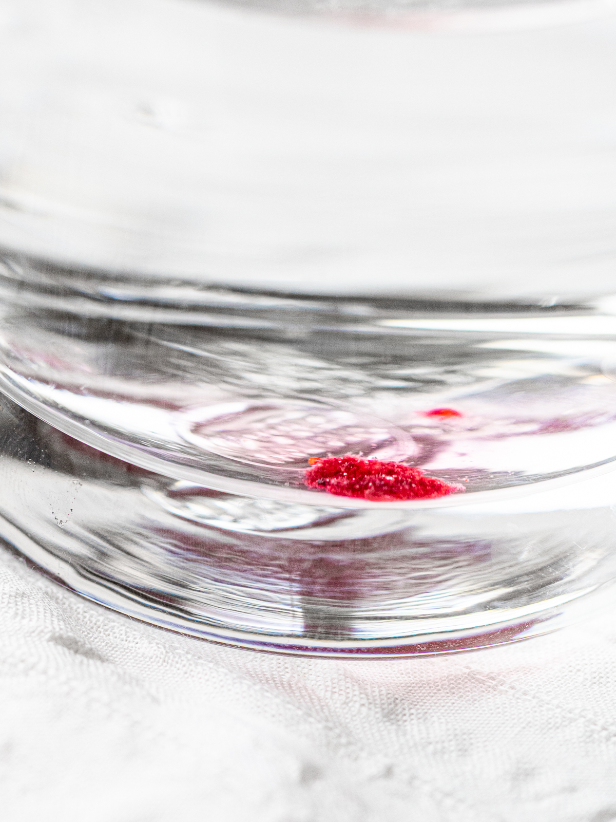 a drop of jam sinks as a soft blob and slowly spreads on the bottom