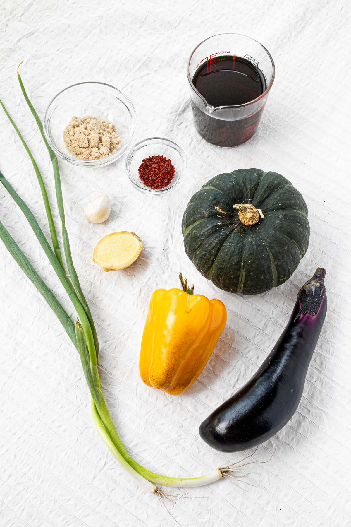 Ingredients for yakibitashi: chili flakes, sugar, garlic, ginger, yakibitashi marinade mixture, kabocha, bell pepper, eggplant, scallions