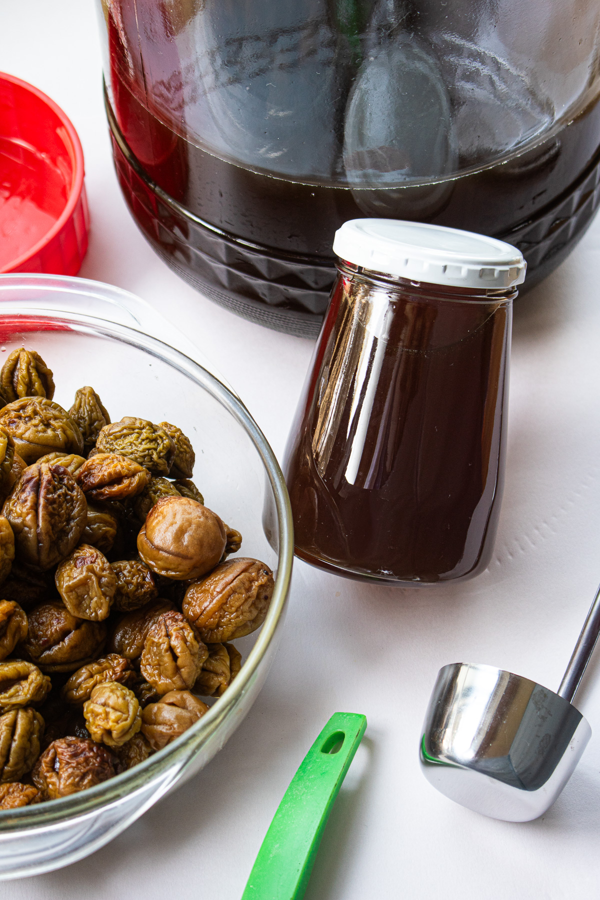 Korean plum extract(Korean green plum syrup) in jar and leftover plums in a glass bowl