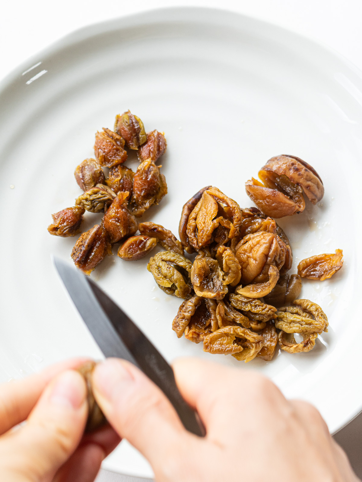 Removing pits from maesil plums with a knife for jangajji