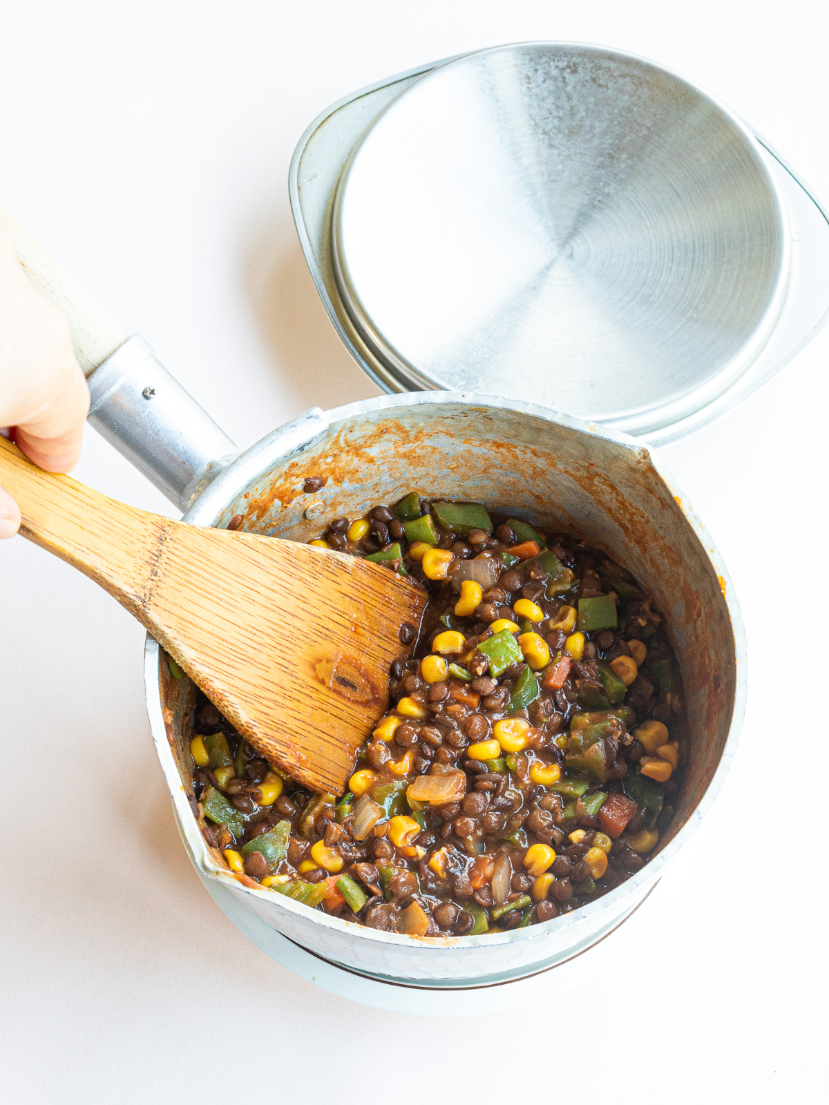 Sauteed vegetables and lentils being stir-fried together.