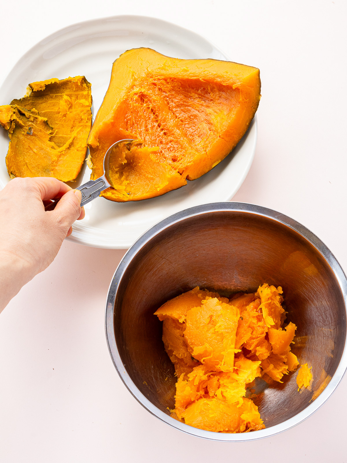 Scooping steamed kabocha squash into a bowl — prepping for vegan pumpkin porridge