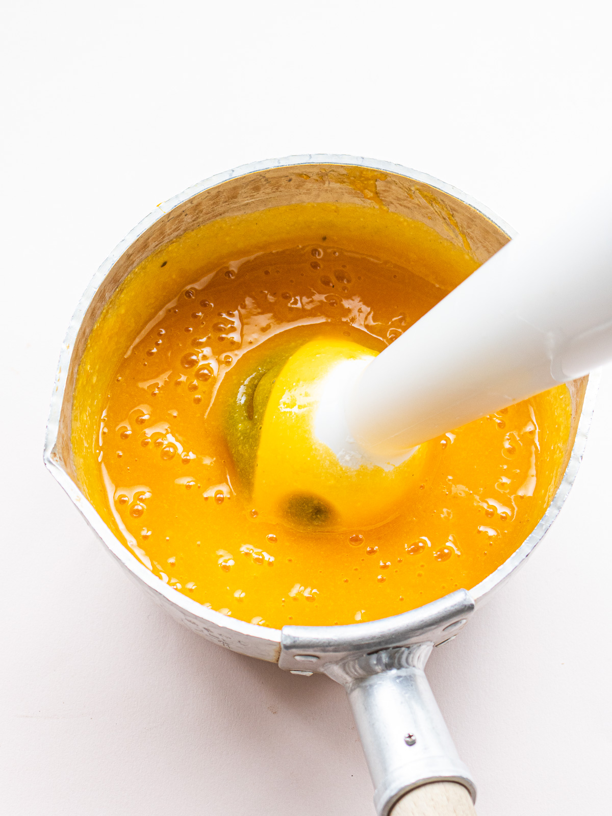 Blending pumpkin and glutinous rice with a hand blender — making smooth vegan porridge