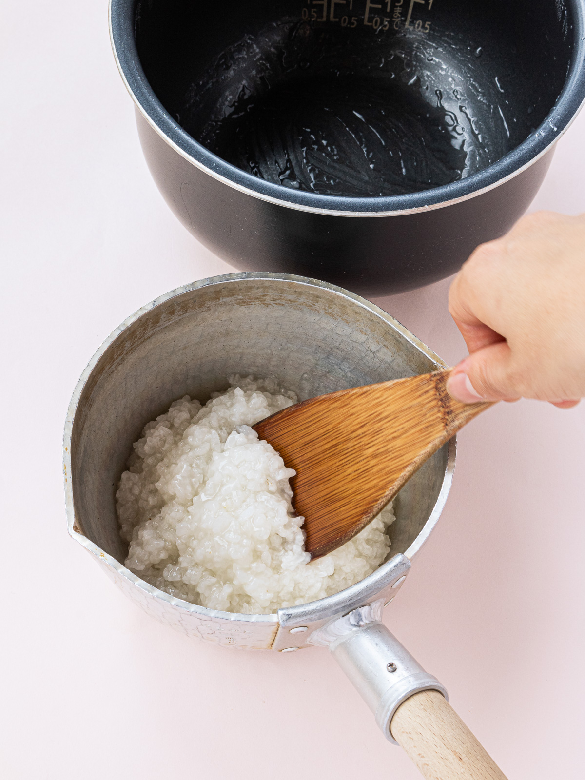 Glutinous rice porridge cooked in a rice cooker, being transferred to a pot
