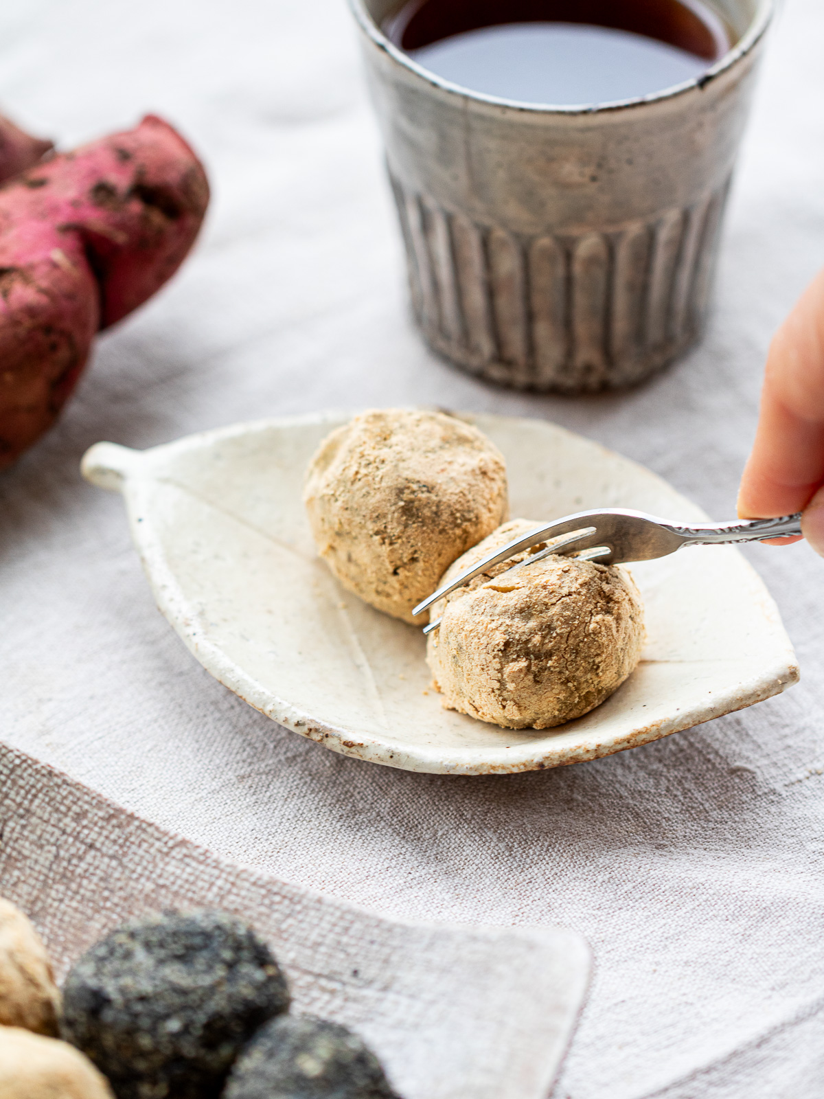 Leftover baked sweet potato bliss balls coated in kinako on white plate