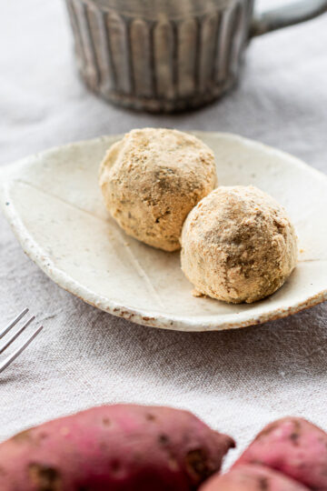 Leftover baked sweet potato bliss balls coated in kinako on white plate