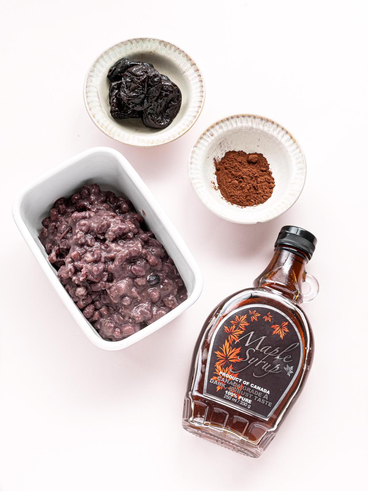 ingredients for vegan chocolate frosting with adzuki beans, cocoa powder, prunes, and maple syrup