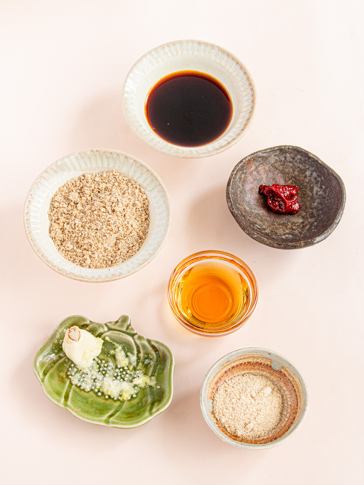Ingredients for vegan Korean bibimbap sauce: soy sauce, gochujang, ground sesame seeds, toasted sesame oil, garlic, and sugar