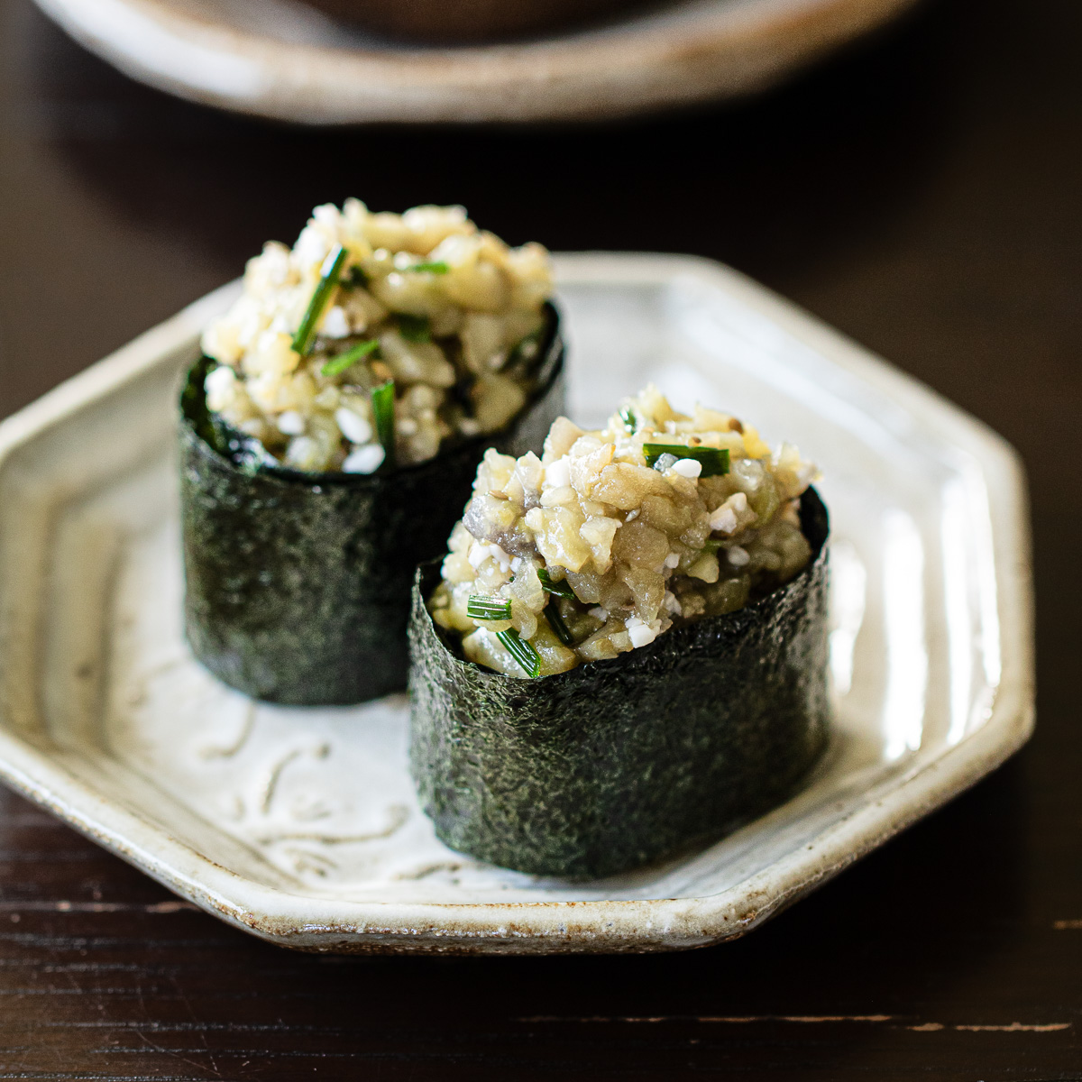 Vegan eggplant gunkan sushi with shio koji topping arranged on white plate, Japanese plant-based sushi recipe