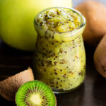 Homemade apple and kiwi jam in glass jar with fresh kiwis and apples