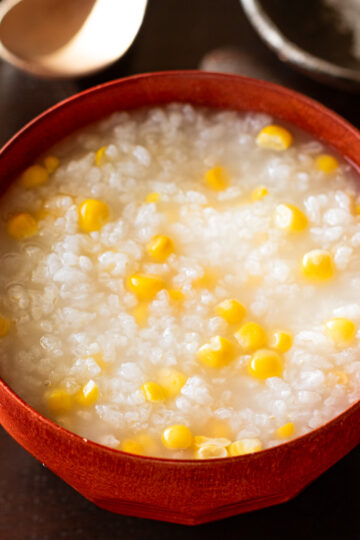 Steaming hot corn congee made in rice cooker with tender rice and sweet corn