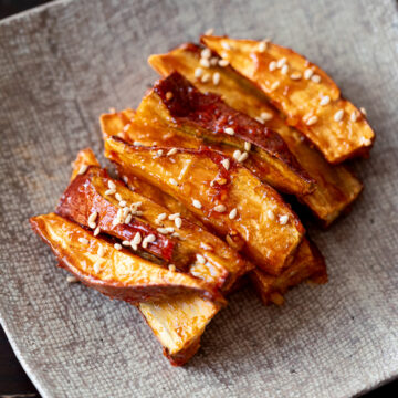 Toaster oven roasted sweet potato sticks coated in sweet and spicy Yangnyeom sauce, a Korean-inspired vegan snack.