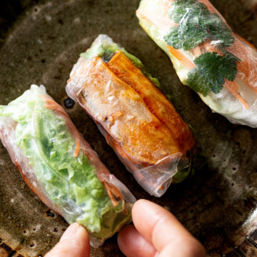 Vegan fresh summer rolls with sweet and spicy yangnyeom sweet potato sticks, cilantro, lettuce, and carrot wrapped in rice paper