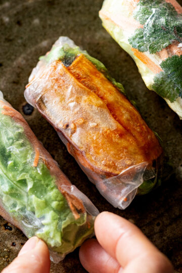 Vegan fresh summer rolls with sweet and spicy yangnyeom sweet potato sticks, cilantro, lettuce, and carrot wrapped in rice paper
