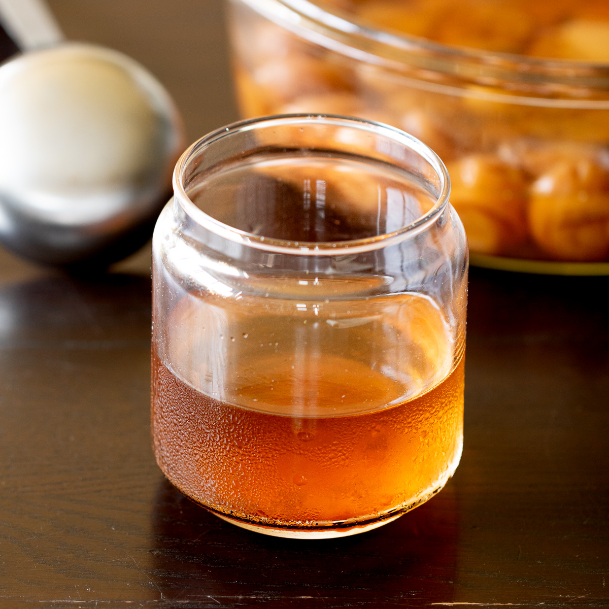 Homemade ume plum vinegar in a glass jar — clear and pale orange yellow