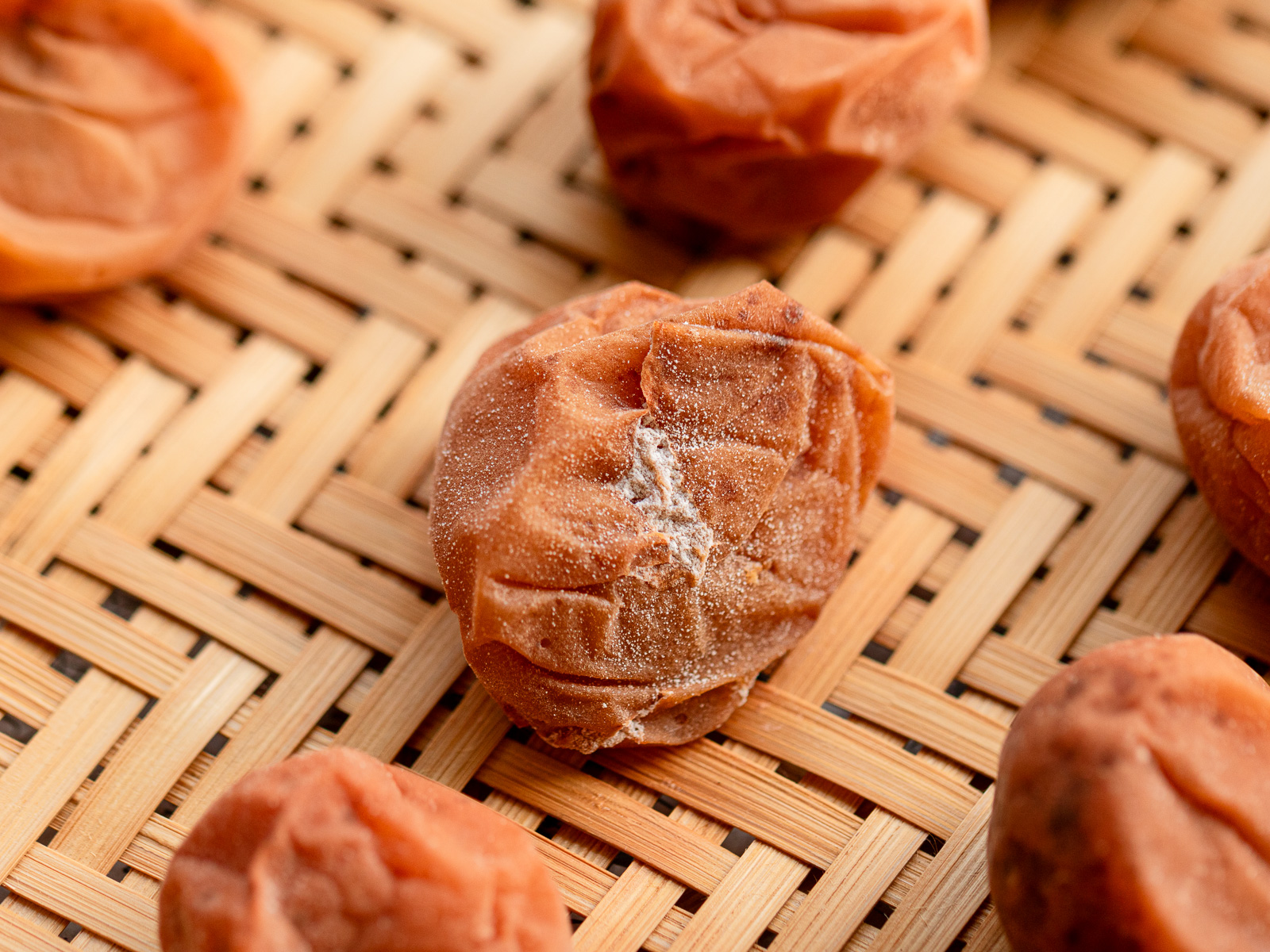 White salt crystals on trimmed umeboshi during drying — not mold, just salt