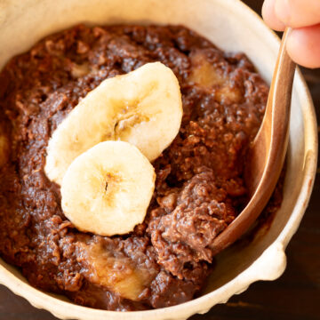 A bowl of creamy chocolate banana oatmeal porridge