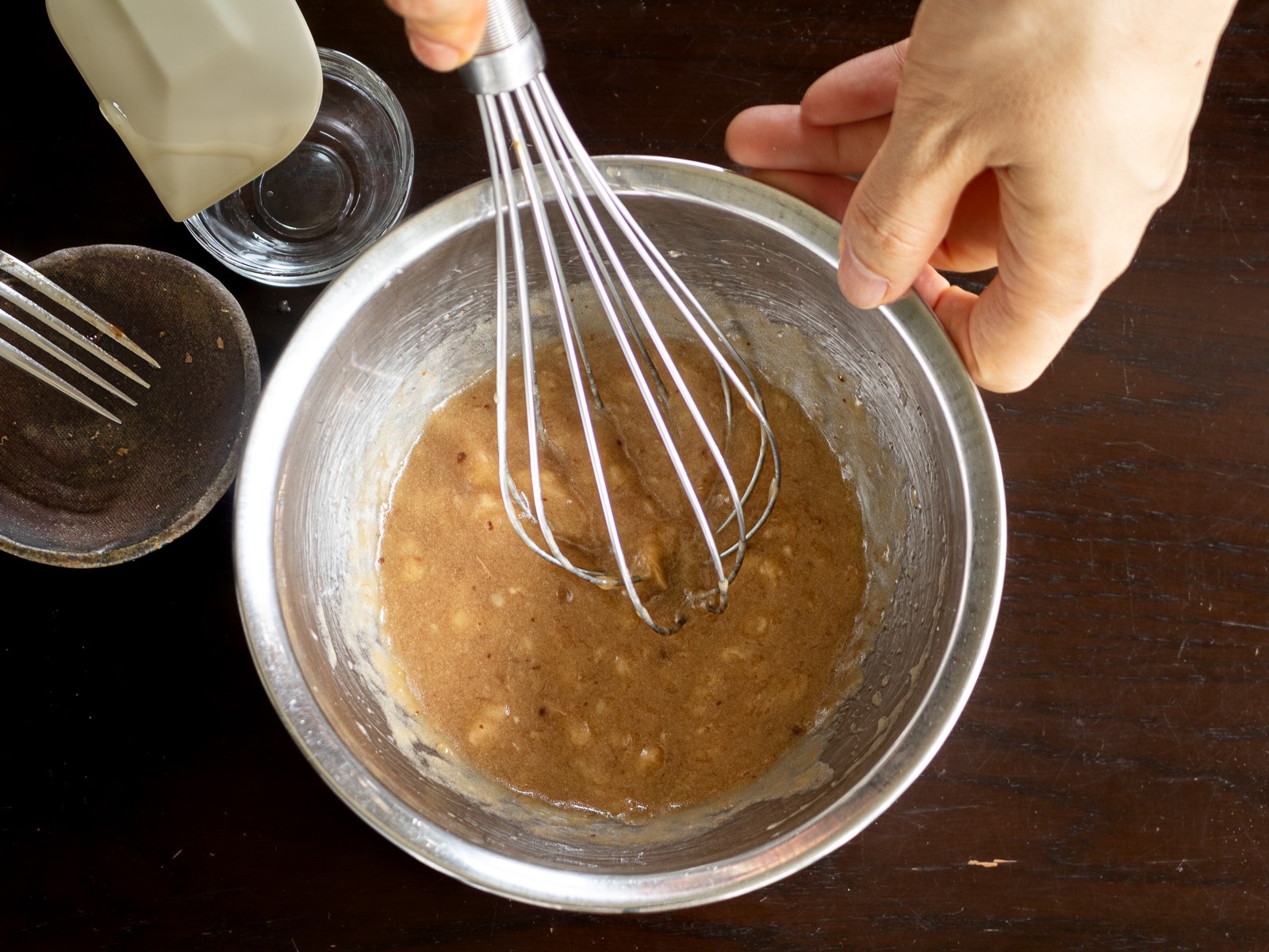 ボウルで完熟バナナと植物油、粉末黒糖を混ぜる工程。甘さ控えめでヘルシーなヴィーガンバナナブレッド作り