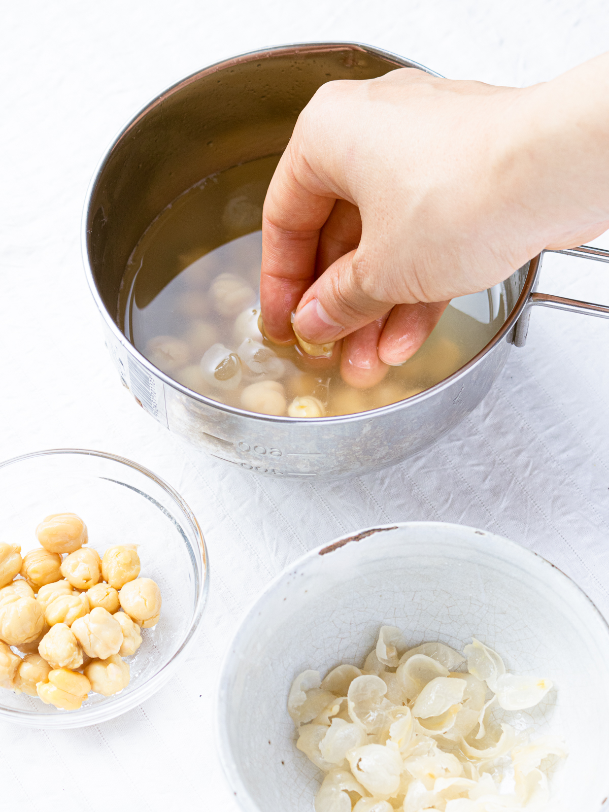 水を張ったボールにひよこ豆を入れて皮を剥いている