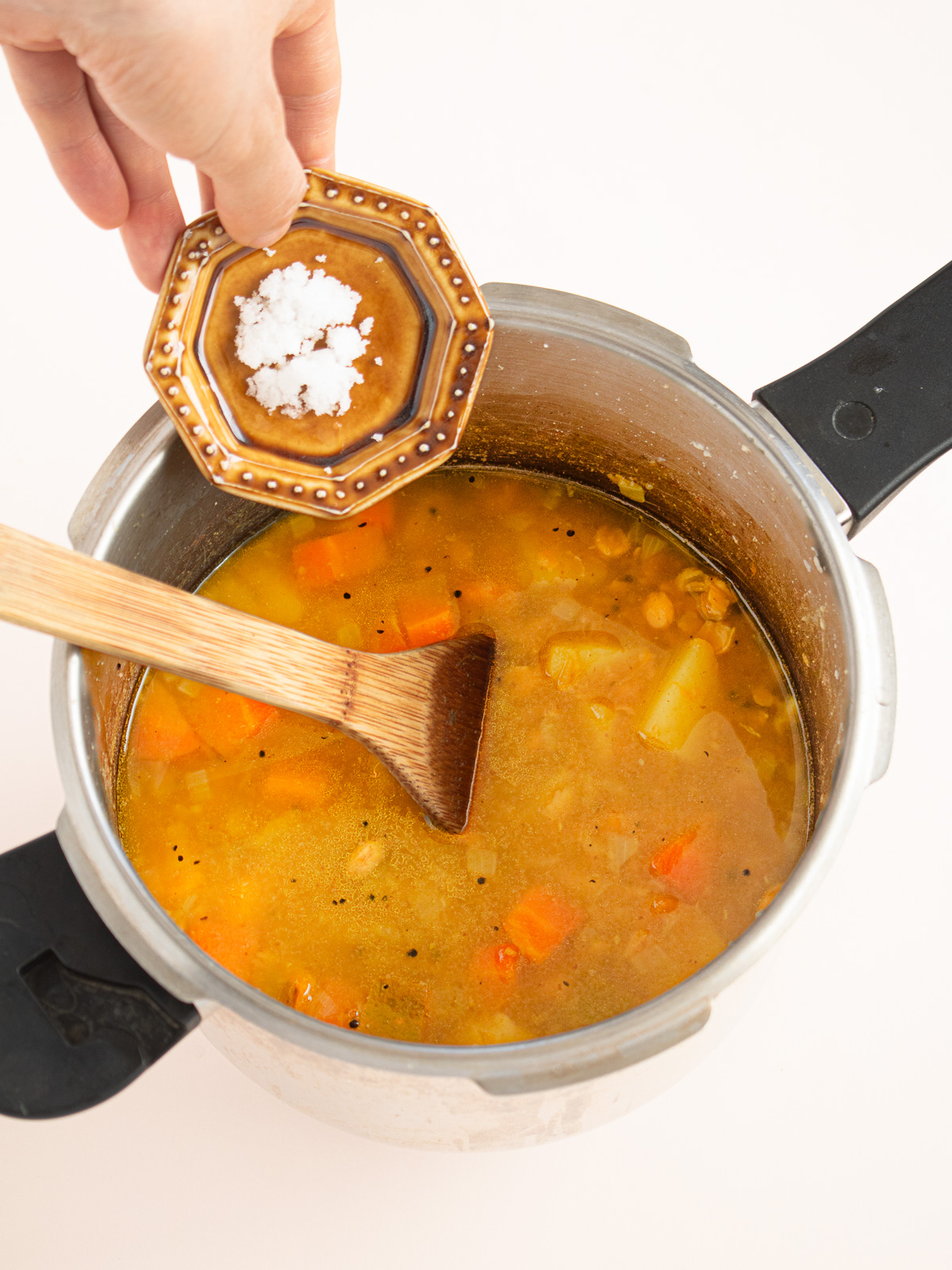 圧力鍋で煮たひよこ豆のカレーに塩を加えているところ