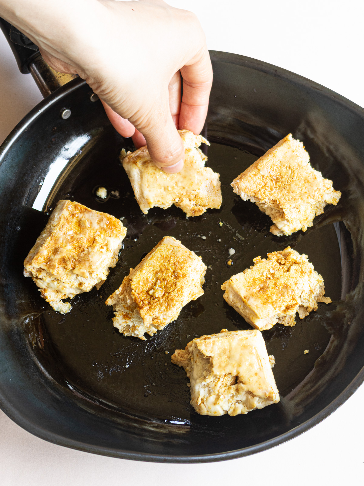 Oil a frying pan before heating, and coat the surface of the frozen tofu with oil.