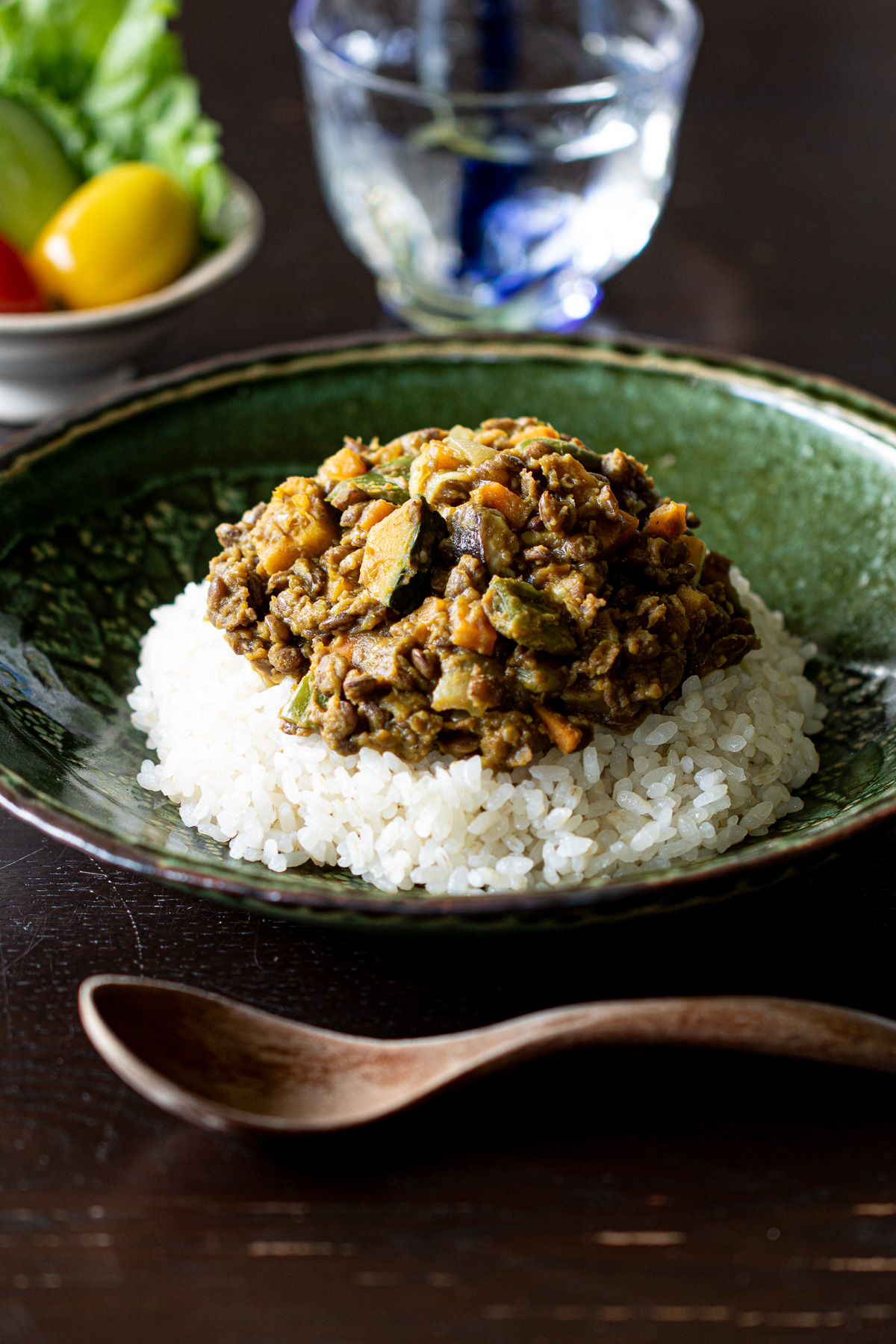 器に盛られたレンズ豆とたっぷり野菜のヴィーガンドライカレー。日本風のやさしい味つけと夏野菜が彩る、夏にぴったりの一皿。