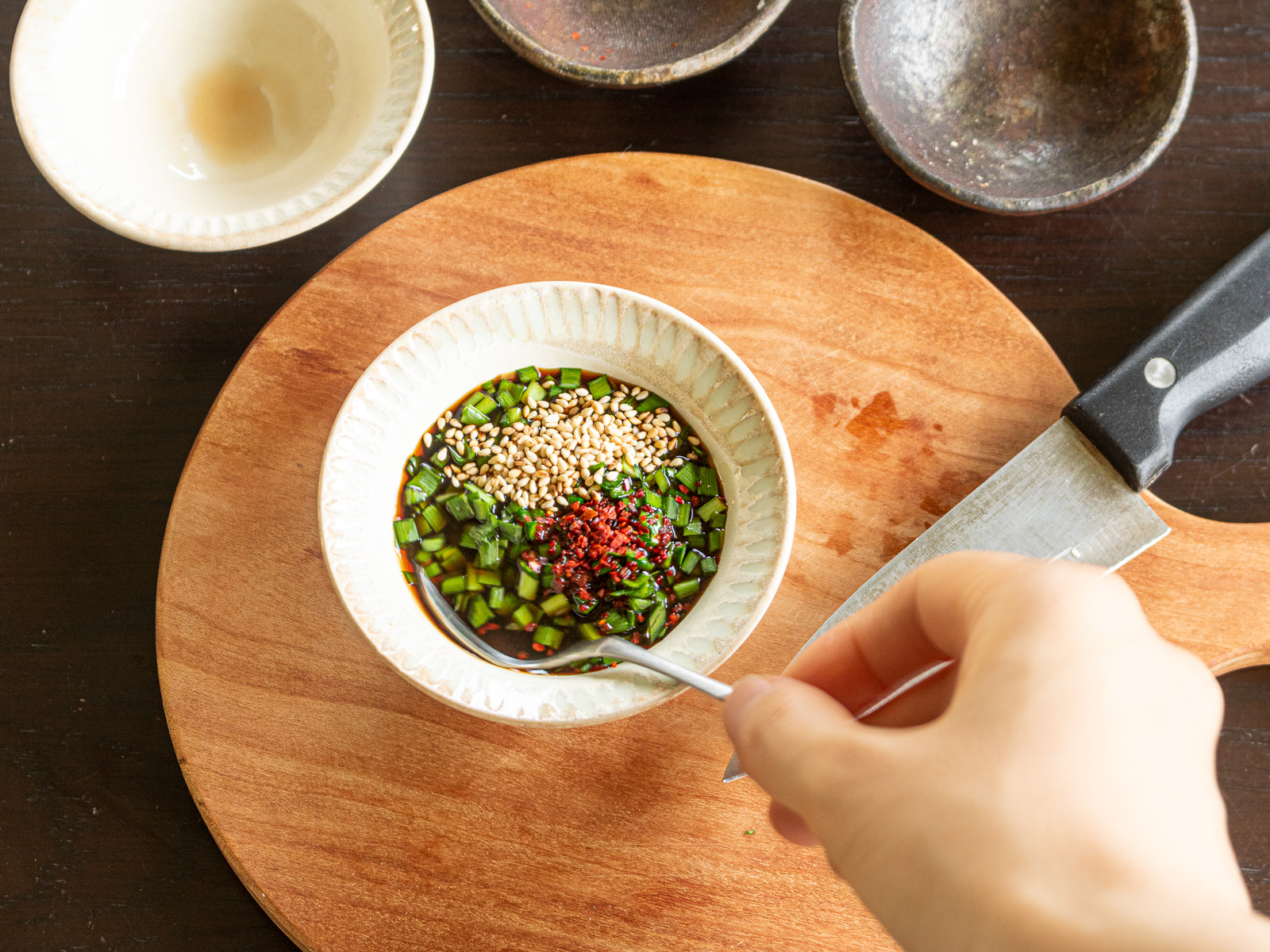 刻んだニラと生姜、調味料を混ぜて香味だれを作る工程