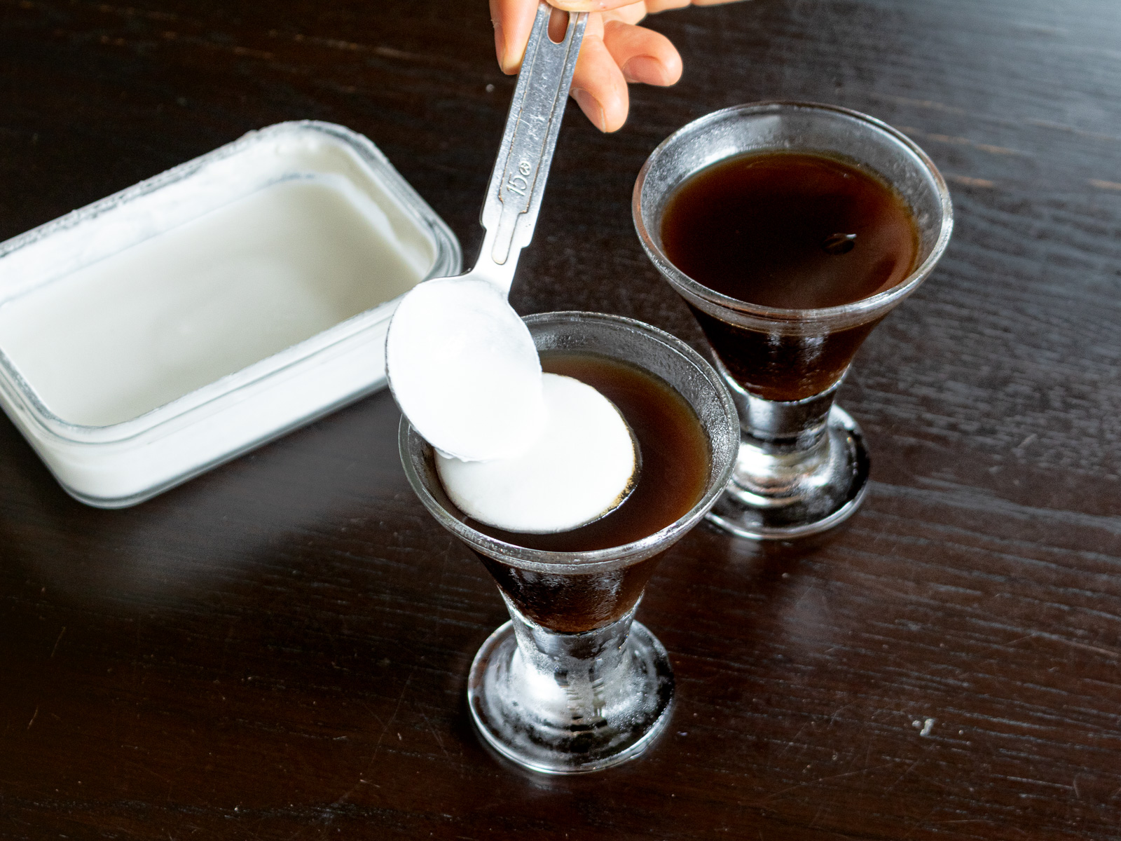 しっかり冷やし固めたコーヒーゼリーにココナッツクリームをかけているところ