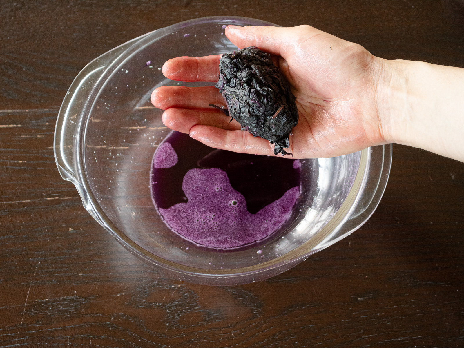 Sprinkling the remaining salt, massaging again until more reddish-purple liquid appears, then squeezing and discarding it.