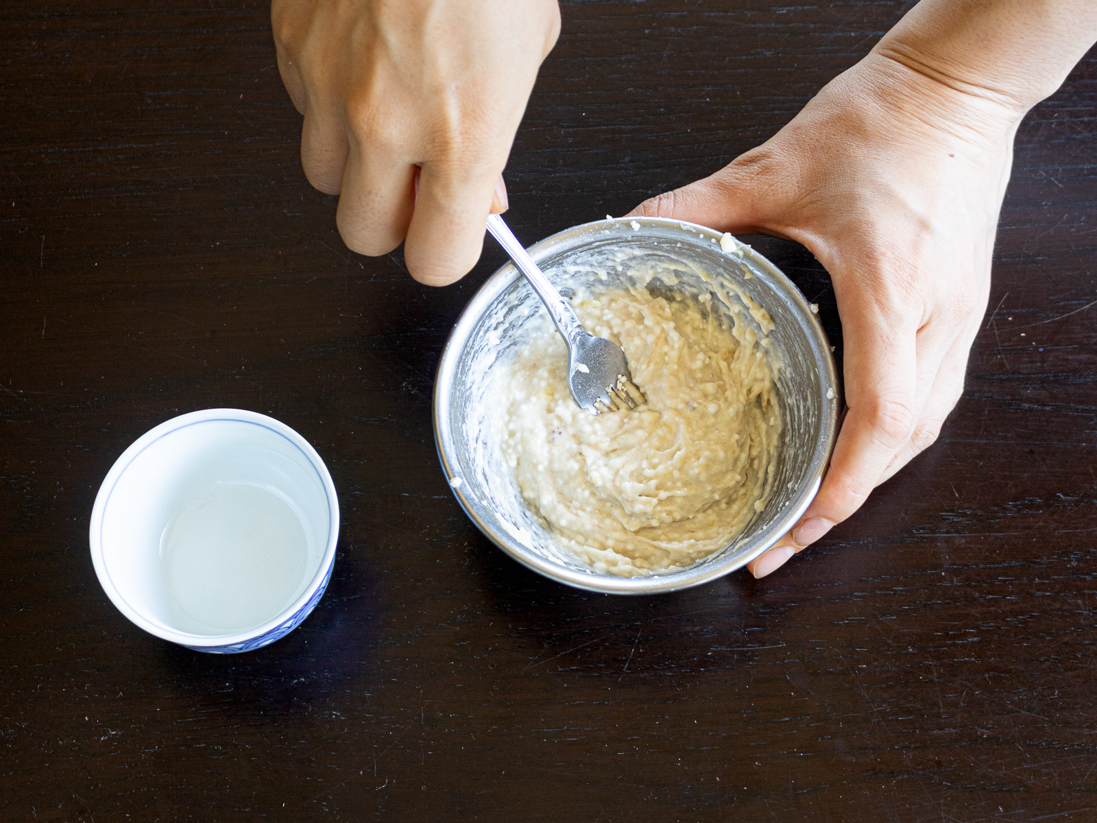 Mixing shiratamako flour into mashed banana until fully incorporated for chewy vegan dumplings.
