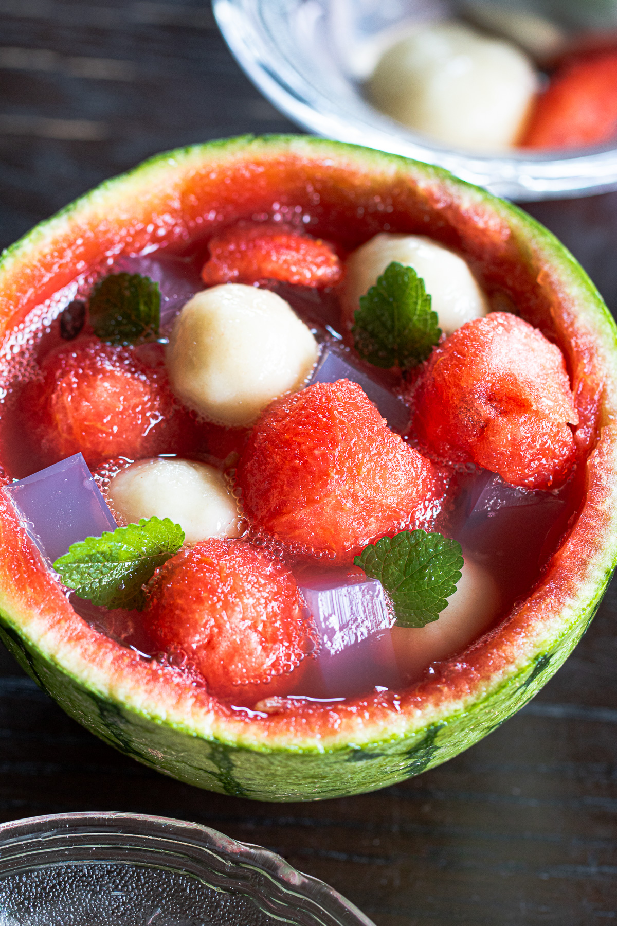 Refreshing vegan dessert: chewy banana mochi and pink agar jelly floating in fizzy watermelon punch