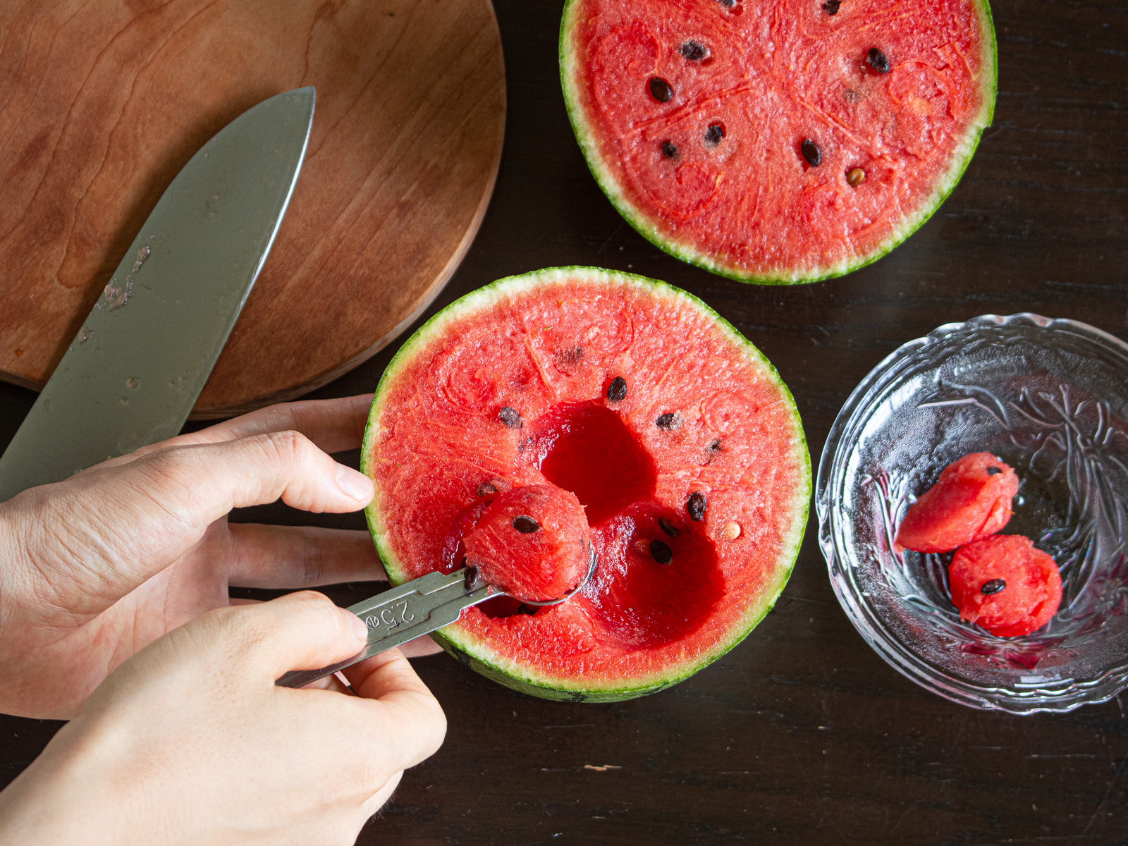 Cut the watermelon in half and scoop out balls of flesh using a melon baller or spoon.