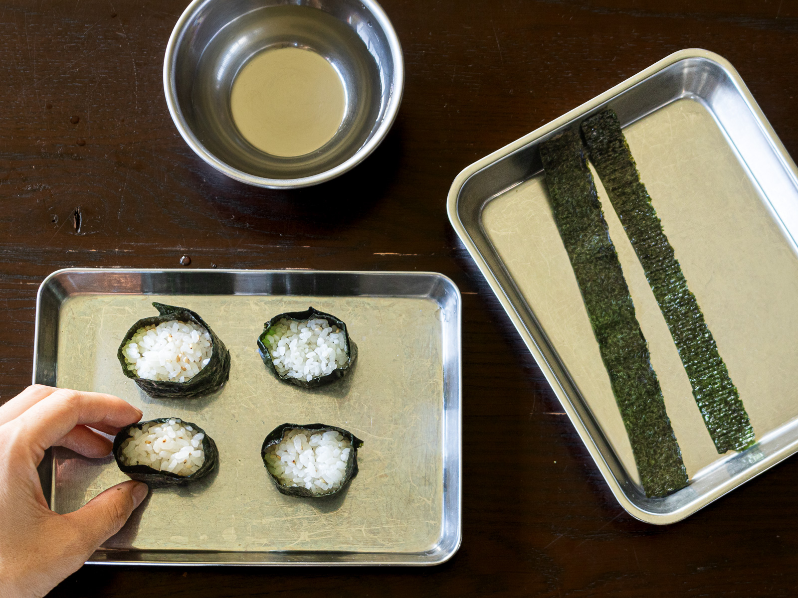 握ったご飯に海苔を巻きつけて軍艦寿司の形を作っている様子｜ヴィーガン寿司のベース