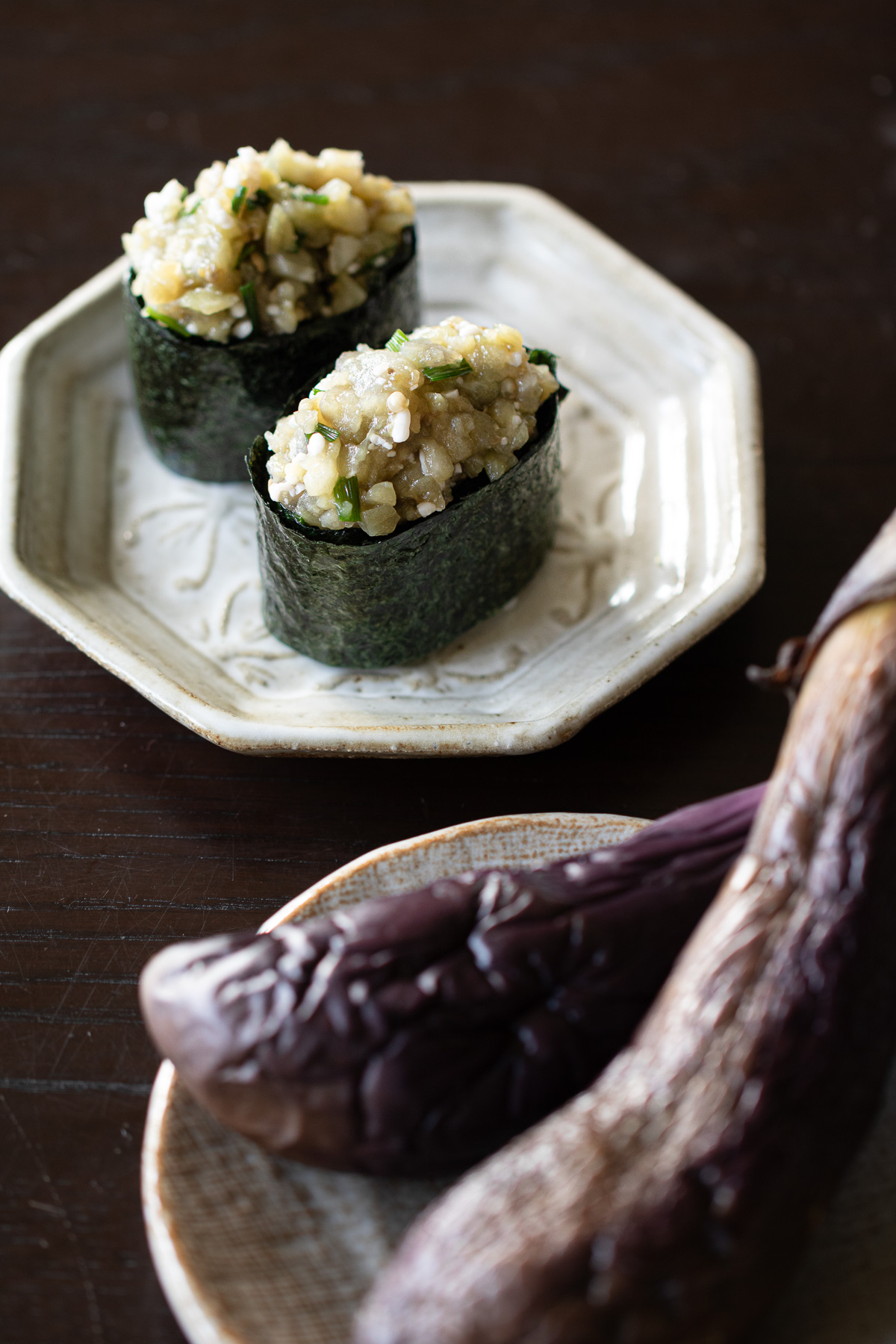 Silky vegan gunkan sushi filled with steamed autumn eggplant and fermented koji, served on minimalist plate