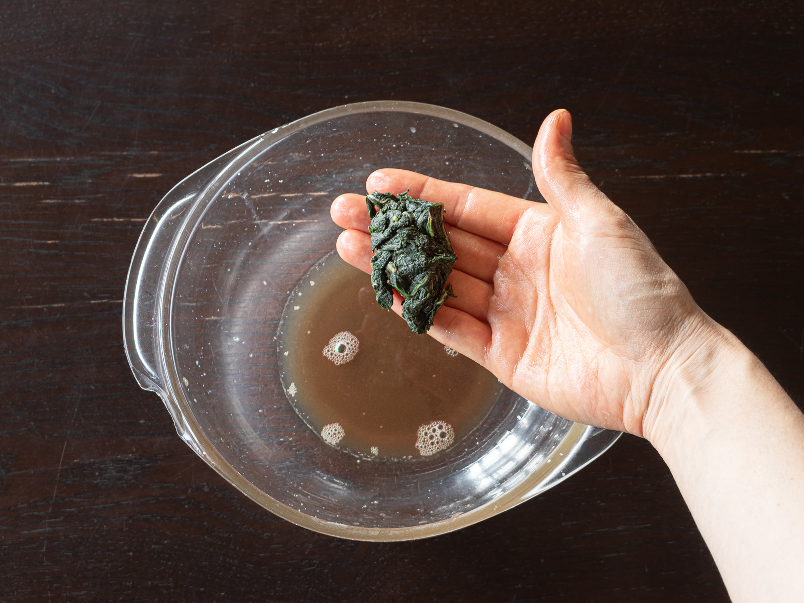 茶色い汁が出るまでよく揉んだえごまの葉。ぎゅっと絞って出た汁を捨てる