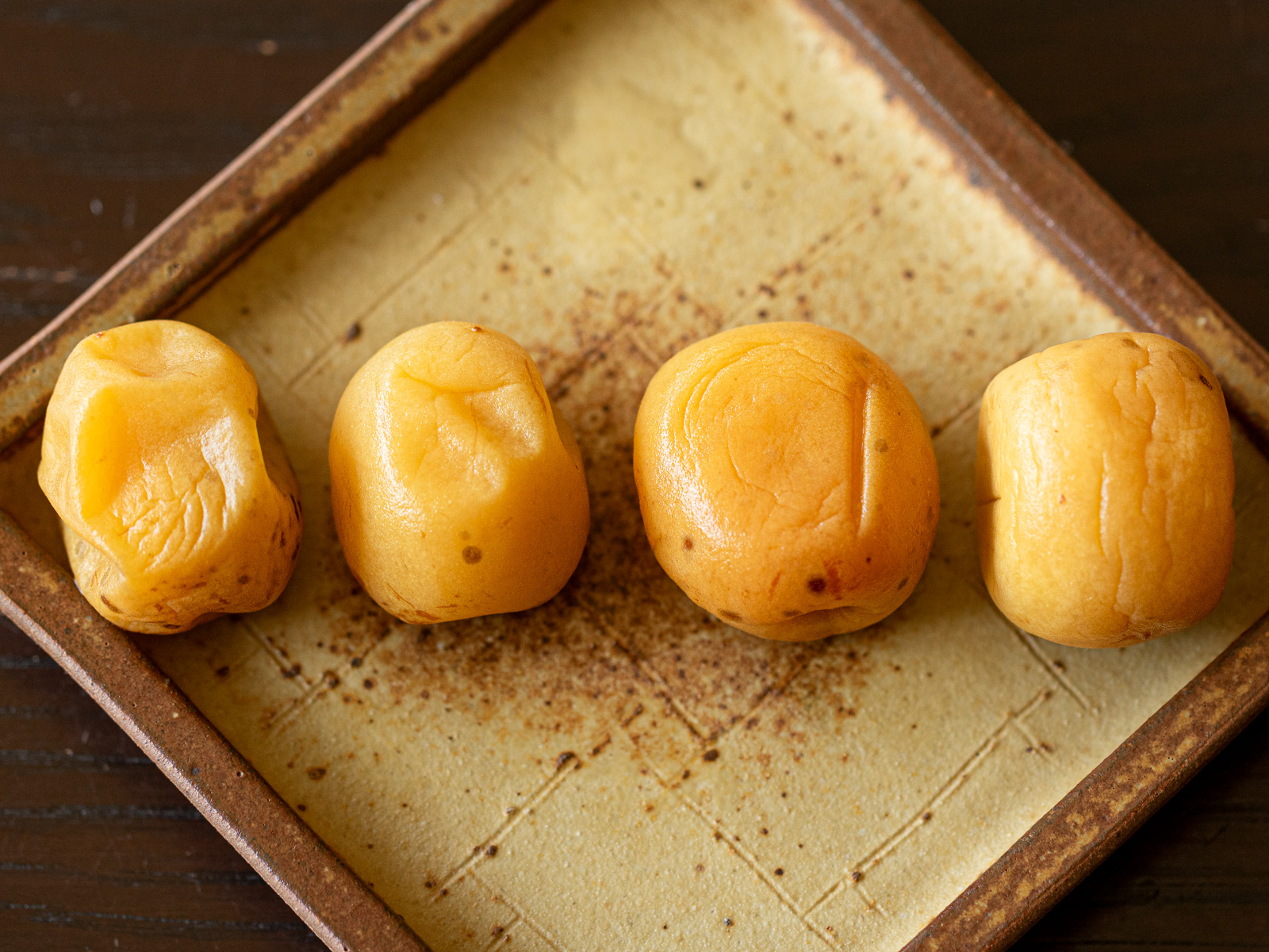 干す前の4つの梅干しの様子。左から柔らかい順に、梅酢大さじ２、ホワイトリカー大さじ２、梅酢大さじ１、梅酢・ホワイトリカーなしで漬けた梅漬け。