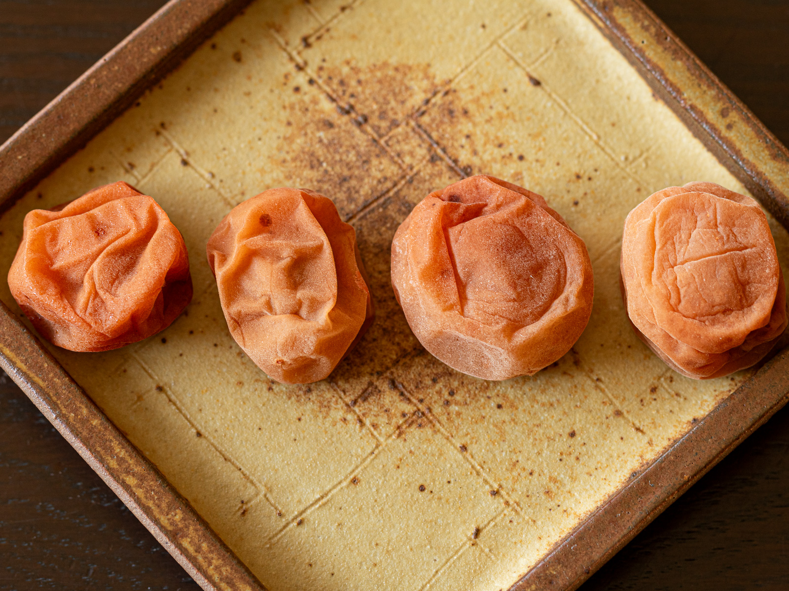 干した後の4つの梅干しの様子。左から柔らかい順に、梅酢大さじ２、ホワイトリカー大さじ２、梅酢大さじ１、梅酢・ホワイトリカーなしで漬けた梅漬け。