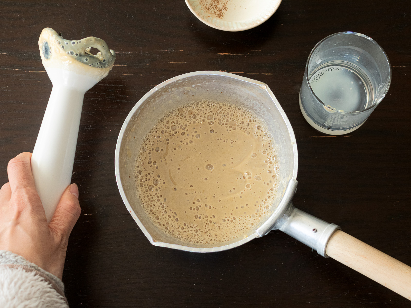 鍋に焼き芋と豆乳を入れ、ハンドブレンダーで混ぜる様子。さつま芋ラテの作り方
