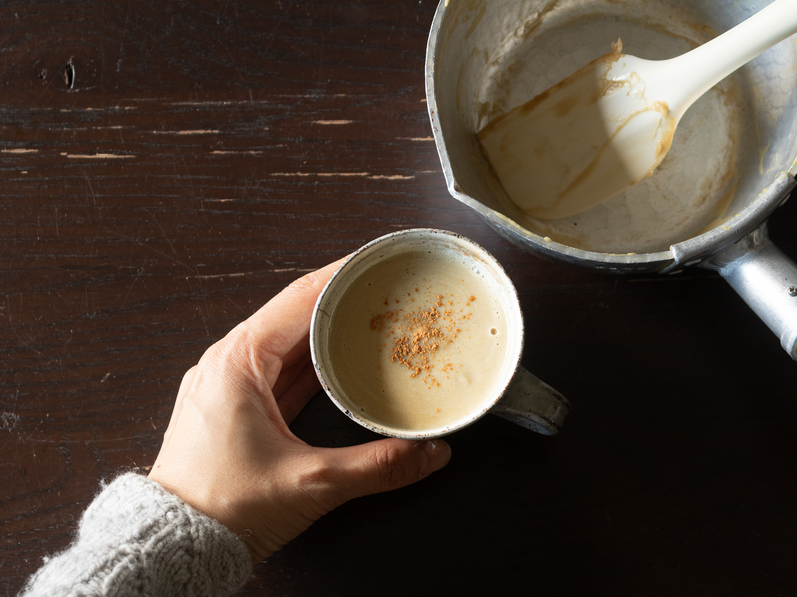 カップに注いだ完成したさつま芋ラテ。シナモンパウダーをトッピング