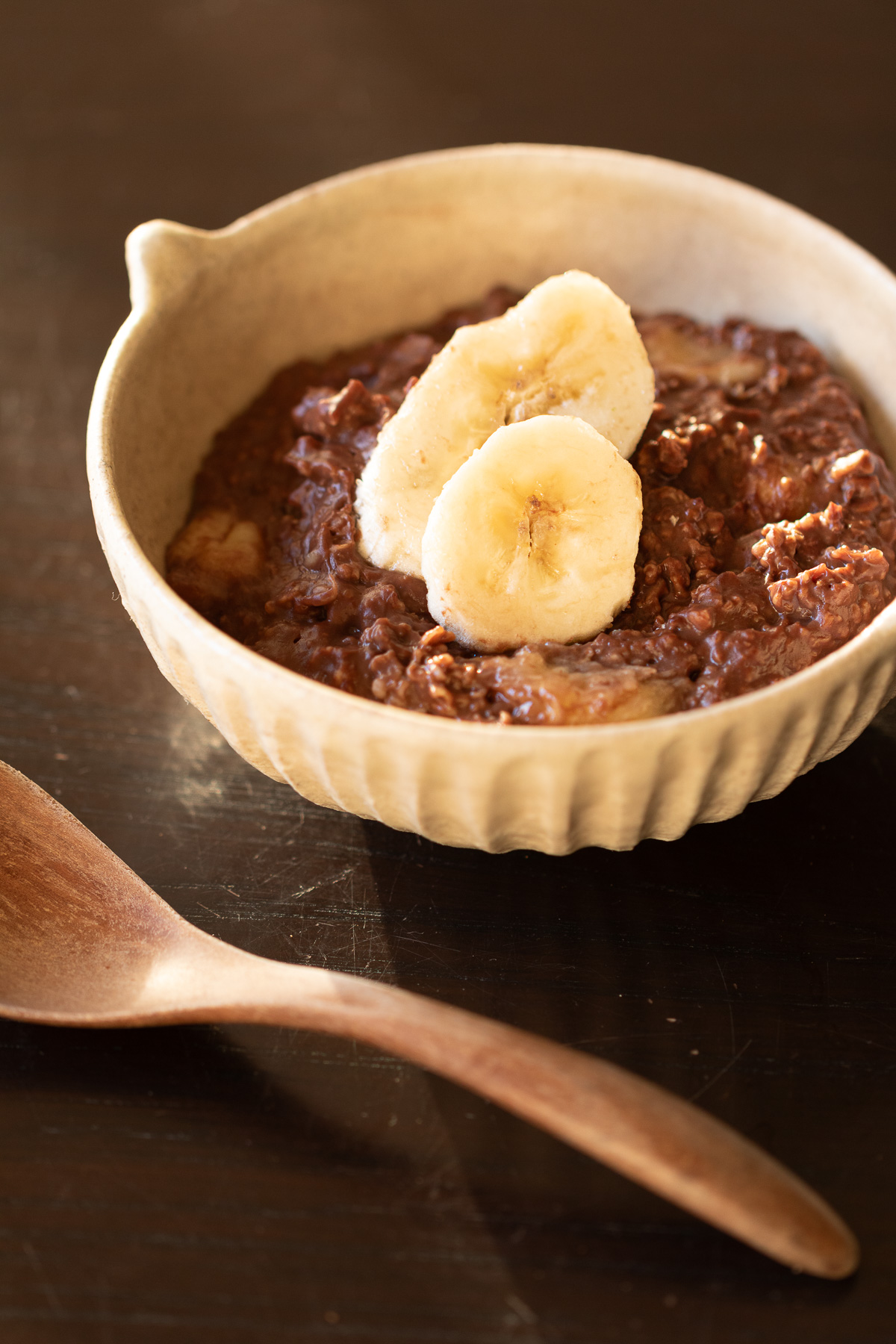 お皿に盛られたチョコレート風味のヴィーガンオートミール粥。濃厚なココアとバナナ甘味で満足感のある一皿に。