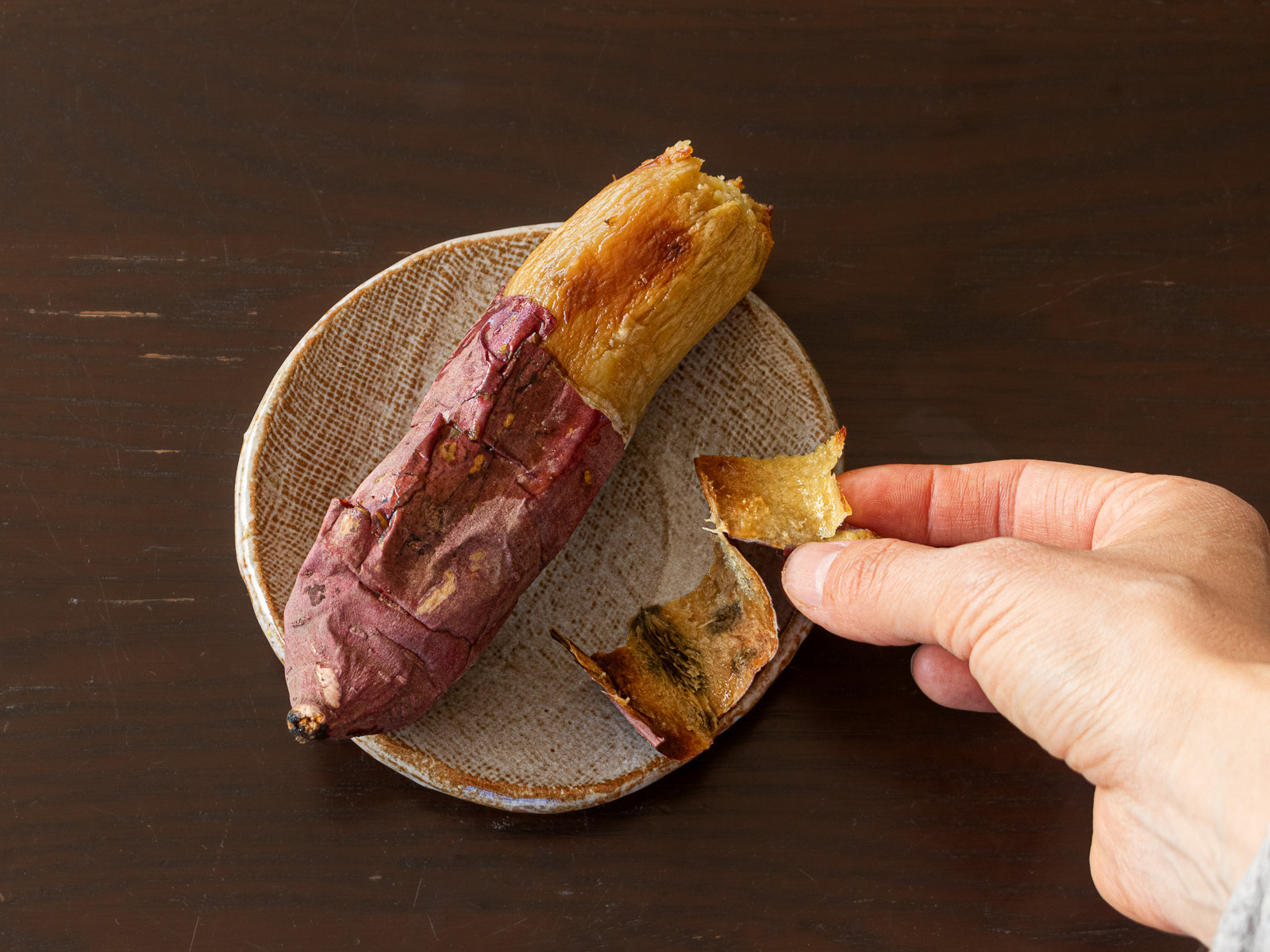 焼き芋の皮をむく様子